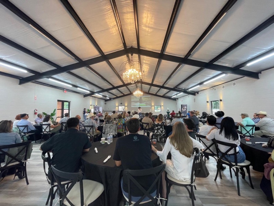 Inspira Ranch event hall interior set up for a corporate conference with projector and round tables — Livingston TX